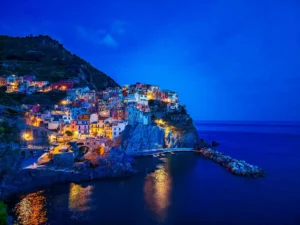 בתים צבעוניים של הכפר מאנארולה בצ'ינקווה טרה צמודים לצוקים תלולים ומשקיפים אל הים התיכון בשעת הערביים