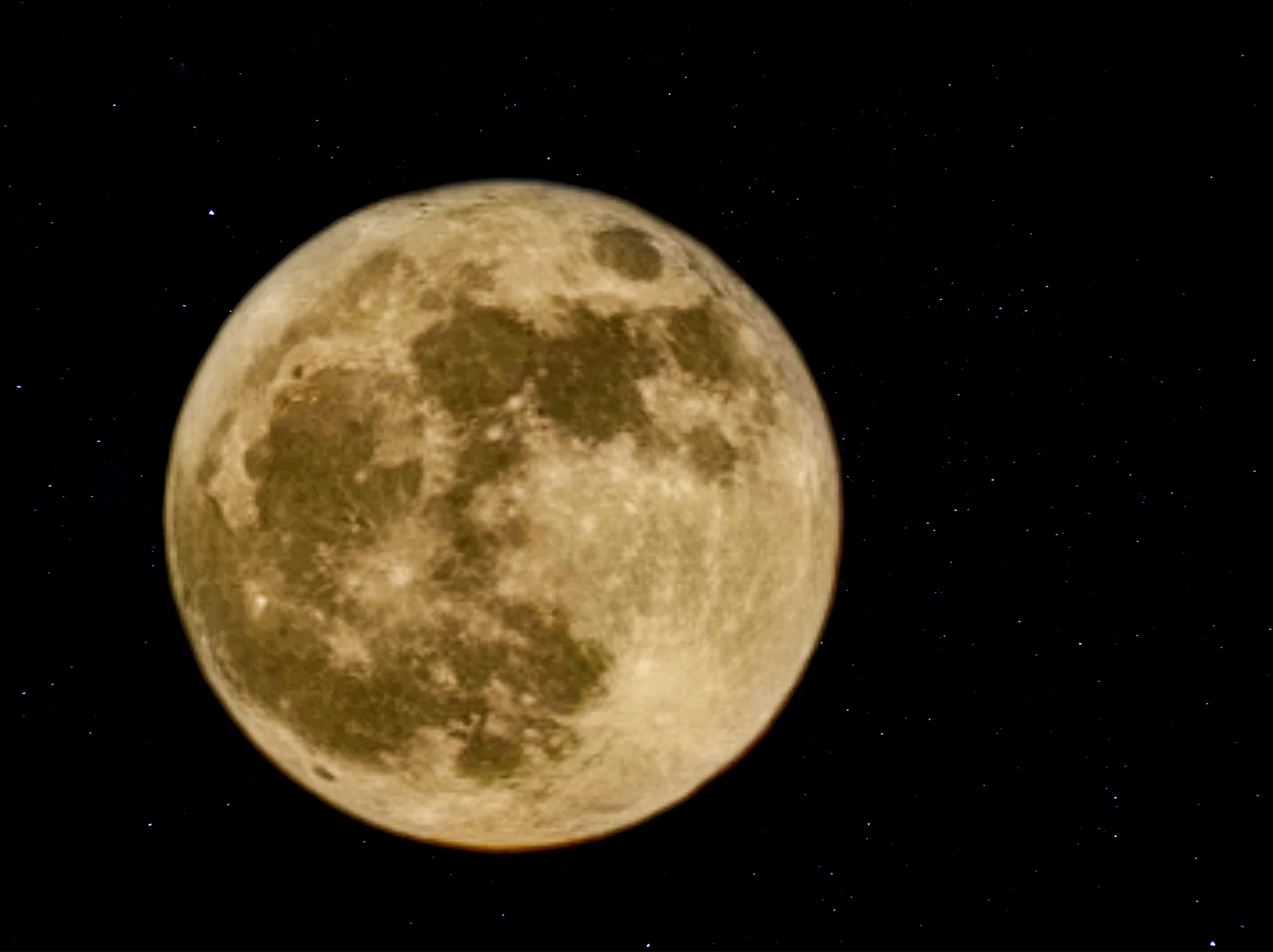 ירח מלא במרכז שמי הלילה, מוקף בכוכבים מנצנצים, התמונה לוכדת את המכתשים העתיקים של הירח בפירוט מלא חיים.