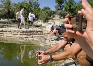 משתתפים בסדנת צילום בסמארטפון מצלמים ליד הבריכה במעיין התמרים בפארק איילון־קנדה