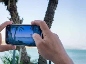 ידיים מחזיקות סמארטפון לרוחב ומצלמות סרטון בכנרת